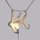 Seletti lampada scimmia accesa appesa da mano e piede in resina di colore bianco